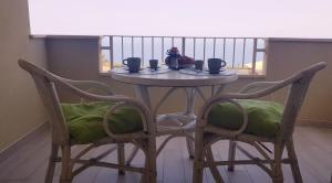a table with two chairs and a table with cups on it at Casa Vacanza Mata in Zambrone
