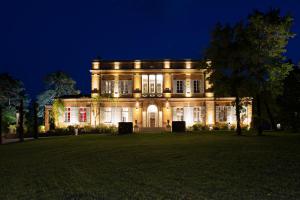 a large house with lights on it at night at Château de Roquefoulet Luxury Guesthouse & Spa in Montgeard