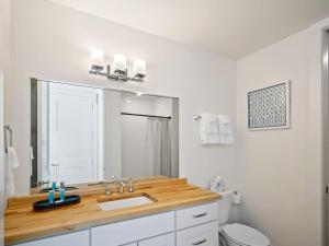 een badkamer met een wastafel, een toilet en een spiegel bij Clover Luxury High-Rise DownTown South Bend in South Bend