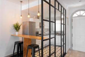 uma cozinha com um balcão de madeira e bancos pretos em Bright 2 Bedroom apartment with parking space and swimming pools in Aloha Gardens em Marbella