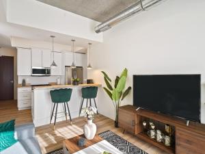 a kitchen and living room with a large flat screen tv at Clover Luxury High-Rise DownTown South Bend in South Bend