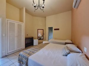 1 dormitorio con 2 camas y lámpara de araña en Hotel Fazenda Cachoeiras Serra da Bodoquena, en Bodoquena