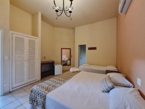 a bedroom with two beds and a chandelier at Hotel Fazenda Cachoeiras Serra da Bodoquena in Bodoquena