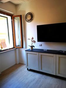 sala de estar con TV de pantalla plana en la pared en Casa vacanza il Campanile, en Alghero
