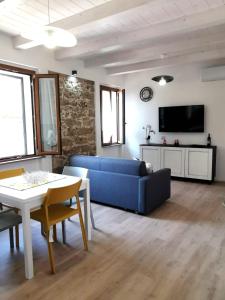 sala de estar con sofá azul y mesa en Casa vacanza il Campanile, en Alghero