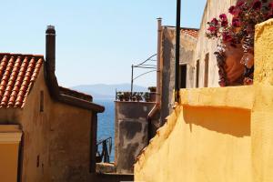 a view of the ocean from between two buildings at Casa vacanza il Campanile in Alghero