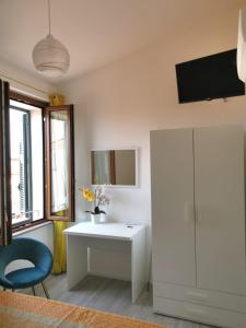baño con escritorio blanco y silla azul en Casa vacanza il Campanile, en Alghero