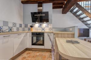 cocina con mesa de madera y encimera en Gîte du Prieuré, en Cosne-Cours-sur-Loire