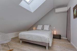 1 dormitorio con 1 cama y 2 velas en el ático en Gîte du Prieuré, en Cosne-Cours-sur-Loire