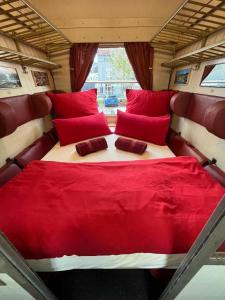 - un lit à l'arrière d'un train avec des oreillers rouges dans l'établissement Übernachten im nostalgischen Bahnwaggon, à Bogen