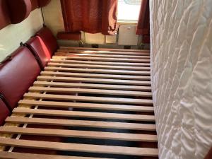 una escalera en un tren con asientos rojos y una cama en Übernachten im nostalgischen Bahnwaggon, en Bogen