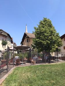 a park with a fence and a tree and a building at Goldengel Design-Suiten Frieda Maria im Herzen von Kaltern in Caldaro