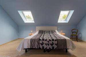een slaapkamer met een bed en 2 dakramen bij Le Faré Pouguois in Pougues-les-Eaux