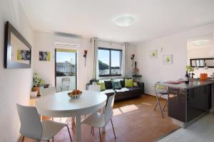 een keuken en een woonkamer met een witte tafel en stoelen bij Ouramar Apartment in Areias de São João