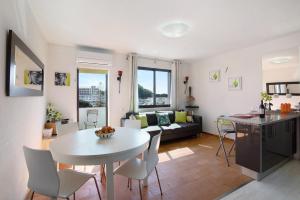 a kitchen and living room with a white table and chairs at Ouramar Apartment in Areias de São João