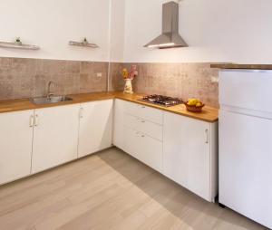 een keuken met witte kasten en een wastafel bij Casa Vacanza Grifone in Zaccanopoli