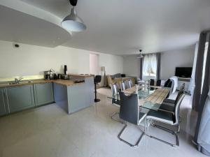 a kitchen and living room with a table and chairs at La Maison De Delsy in Binson-et-Orquigny