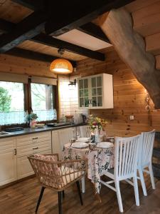a kitchen with a table and chairs in a room at Chata Lawendowa in Sasino
