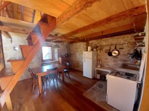 a kitchen and dining room with a table and a refrigerator at Makina in Nerežišće