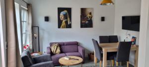 モニキンダムにあるDe Rokerijの紫色のソファとテーブル付きのリビングルーム