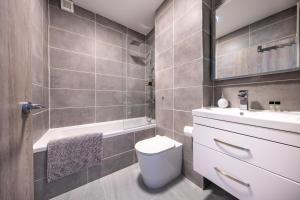 La salle de bains est pourvue de toilettes, d'un lavabo et d'une baignoire. dans l'établissement Ash View Place 4 -Heathrow - Thorpe Park - Free Parking, à Staines