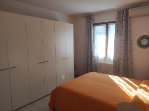 1 dormitorio con cama, armarios y ventana en la casa dei bebi, en Carrara