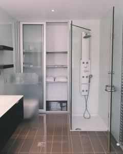 uma casa de banho com um chuveiro e uma cabina de duche em vidro. em Phillyrėa Luxury Villas em Cós