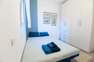 a bedroom with a bed with blue pillows on it at Mandy's Place - By Soroka Medical Center and BGU in Beer Sheva