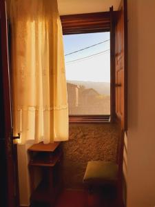 une porte ouverte avec une fenêtre offrant une vue. dans l'établissement Casa do Paço, à Monção
