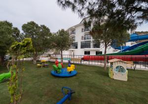 a playground with various play equipment in a park at Dalya Resort Aqua & Spa Hotel Datça in Datca