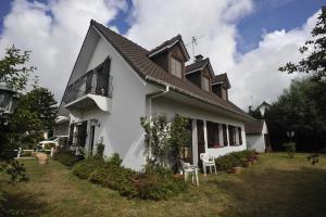 a white house with a balcony and a yard at Location vacances in Cucq