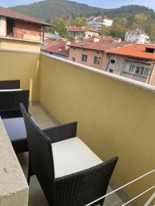 uma varanda com cadeiras e uma mesa num edifício em LUXURIOUS ONE BEDROOM STUDIO IN TOP CENTER em Blagoevgrad