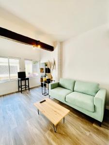 uma sala de estar com um sofá verde e uma mesa de centro em Cosy Home Muret em Chartres