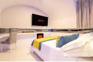een slaapkamer met een bed en een tv aan de muur bij Cifariello Suite in Napels