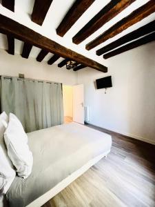um quarto com uma cama branca e uma televisão em Cosy Home Muret em Chartres