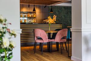comedor con sillas rosas y mesa en Hotel Jamajka, en Wągrowiec