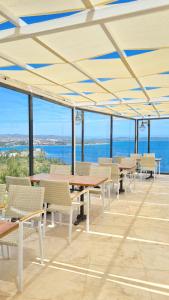 un patio con mesas y sillas y vistas al océano en Dalya Resort Aqua & Spa Hotel Datça, en Datça