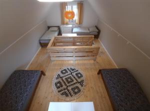 um quarto no sótão com 3 camas e um tapete em Noclegi Różanka em Radomierz
