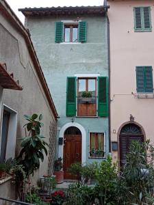 a house with green shutters and a door at Casa di Laura in Chianciano Terme