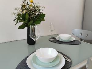 einen Tisch mit zwei Platten und eine Vase mit Blumen in der Unterkunft Ferienwohnung Koblenz Goldgrube in Koblenz