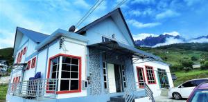 ein weißes Haus mit roten Fenstern und einem Auto in der Unterkunft Suang Noh Homestay Kundasang in Kampong Kundassan