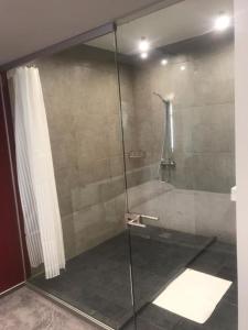 a shower with a glass door in a bathroom at Red Cube Hotel in Kamianets-Podilskyi