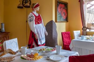 posąg kobiety stojącej obok stołu z jedzeniem w obiekcie Kaszubski Dworek w mieście Sznurki