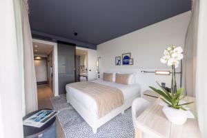 um quarto com uma cama branca e um sofá em Hotel Indigo Cagnes-sur-Mer, an IHG Hotel em Cagnes-sur-Mer