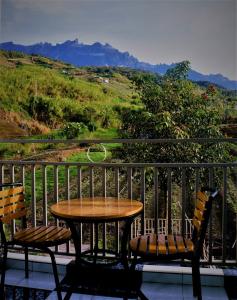 a table and two chairs on a balcony with a view at Suang Noh Homestay Kundasang in Kundasang