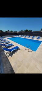 uma fila de espreguiçadeiras e uma piscina em le Petit futé 112 em Biville-sur-Mer
