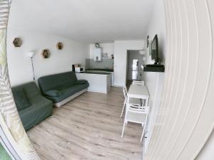 een woonkamer met een groene bank en een tafel bij Studio 4 couchages Port Du Cap d'Agde in Cap d'Agde