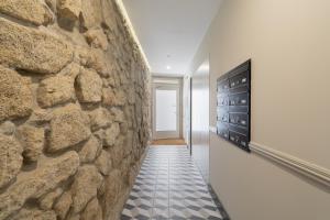 a stone wall in the hallway of a house at Host Wise - Enchanting Design Flat - Premium Location in Porto