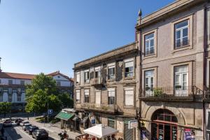 an old building on a city street with cars at Host Wise - Enchanting Design Flat - Premium Location in Porto