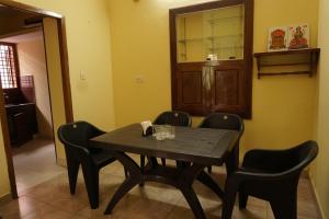 a dining room with a wooden table and chairs at BREEZ VILLA in Madikeri